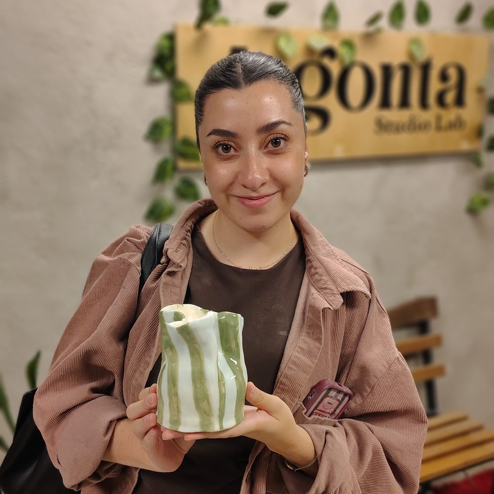 Alumna mostrando la taza de cerámica que hizo en su clase en Gonta Studio Lab