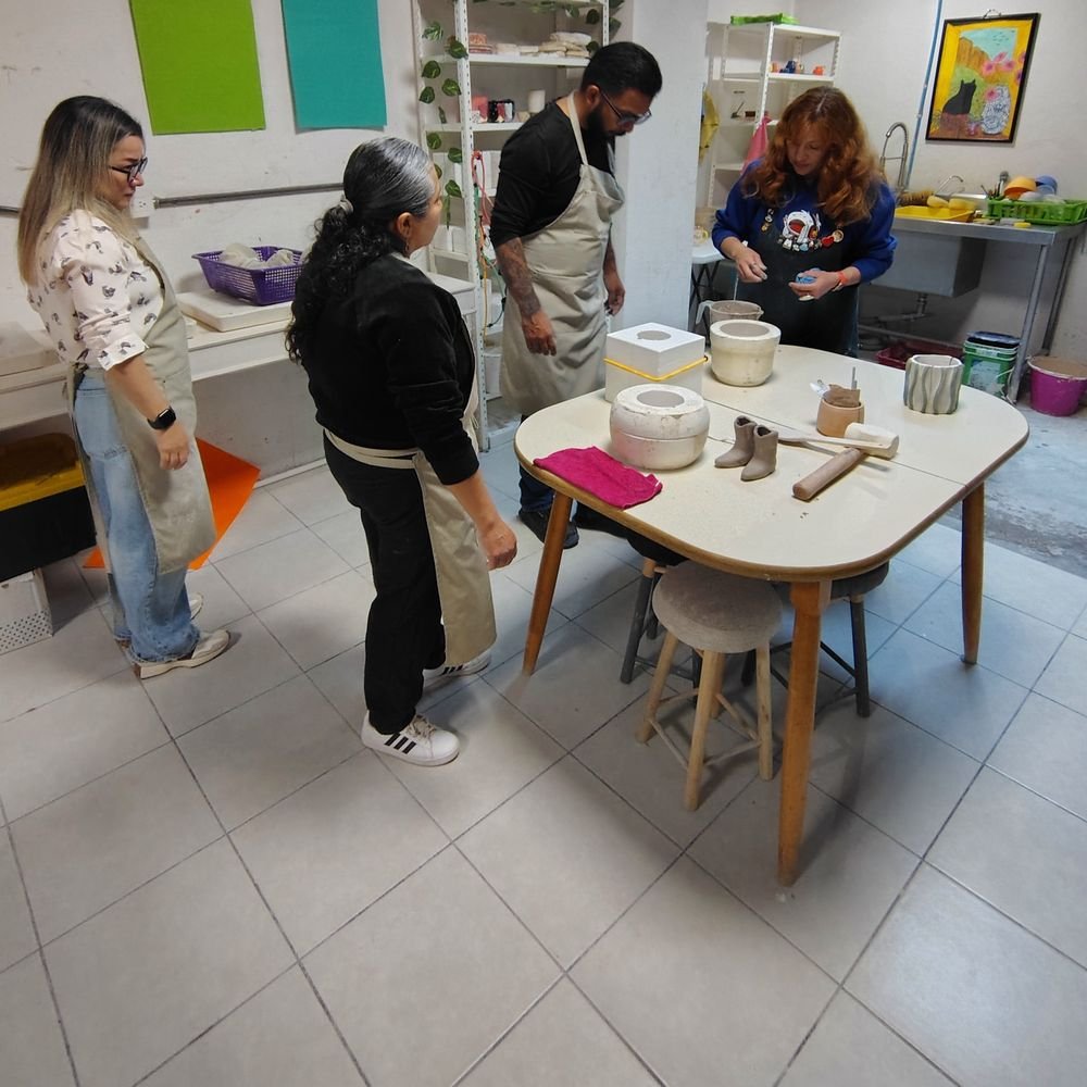 Alumnos alrededor de una mesa con moldes de yeso en una clase de vaciado de cerámica